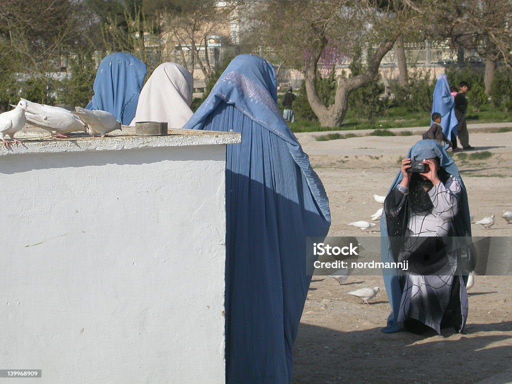Women with burkha taking pictures, Afghanistan The picture was taken next to the large mosq of Mazar-i-Sharif. Although, according to some religious officials, it is said that one should not take pictures of faces, these women do not hesitate to remove the top of their burkha and to take pictures of each other             Afghanistan Stock Photo