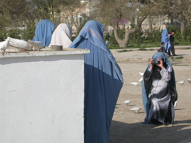 Women with burkha taking pictures, Afghanistan The picture was taken next to the large mosq of Mazar-i-Sharif. Although, according to some religious officials, it is said that one should not take pictures of faces, these women do not hesitate to remove the top of their burkha and to take pictures of each other             muslim photographer stock pictures, royalty-free photos & images