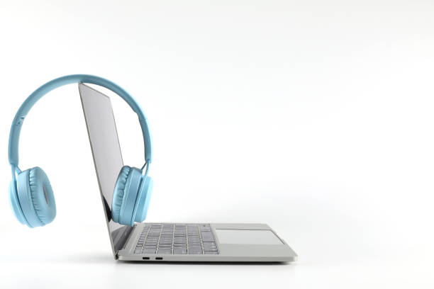 Light blue headphone placed on a laptop isolated on a white background have copy space.