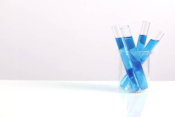 青い液体の試験管をテーブルと白い背景の上に置きます。科学研究 - vial laboratory test tube biotechnology ストックフォトと画像