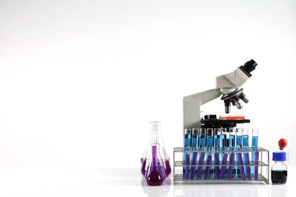 実験室の化学管とガラス製品を備えたテーブル上の顕微鏡、テーブル上の科学研究技術と白い背景 - vial laboratory test tube biotechnology ストックフォトと画像