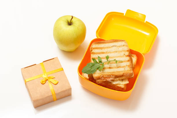 lunch box giallo con fette di pane tostate, formaggio e mela verde. - box cake food lunch foto e immagini stock