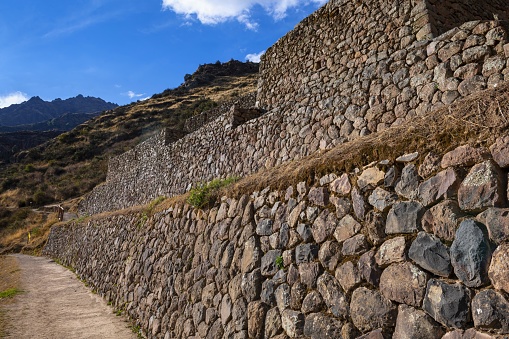 Písac, Peru, November 13, 2021: View of a stone wall in the Inca complex at Pisac. The area is a complex of agricultural terraces, residences, guard posts, watchtowers and a ceremonial centre located along a mountain ridge.