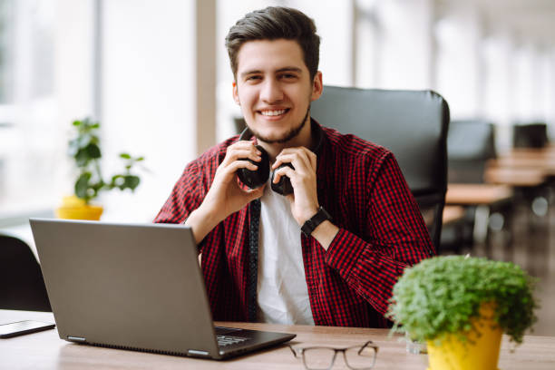 istock Young man works at a computer in the office. Freelancer working from a laptop. Business, education concept. 1399693225