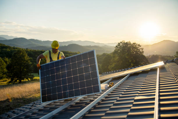 家の屋根にソーラーパネルを取り付ける技術者。 - solar collector ストックフォトと画像