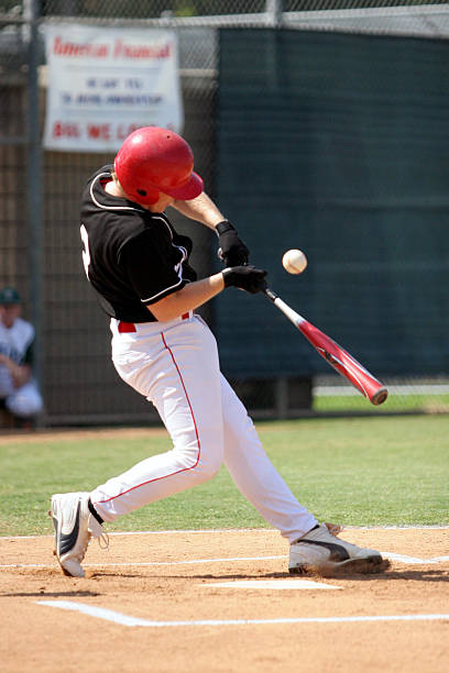 istock Baseball player wearing a red helmet batting a ball 139969444