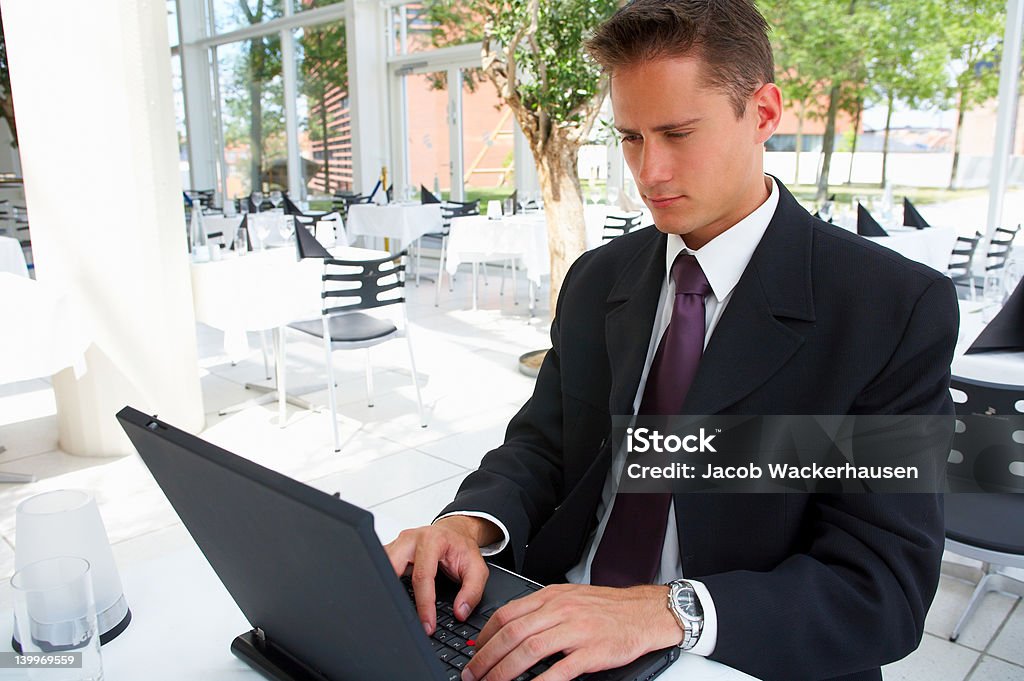 Empresário trabalhando no laptop em um restaurante do local - Foto de stock de 20 Anos royalty-free