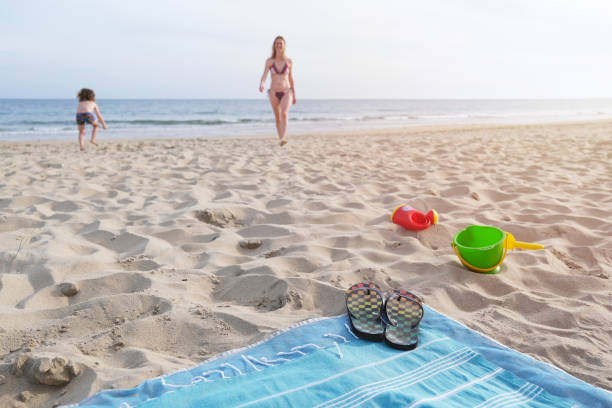 istock Blanket with slippers and toys on beach 1399696377