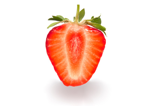 Sliced cross section of a strawberry against white background with a shadow.