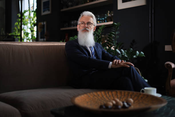 istock Thoughtful confident handsome businessman thinking while sitting on sofa in his modern office about business concept. Coffee break. 1399698975