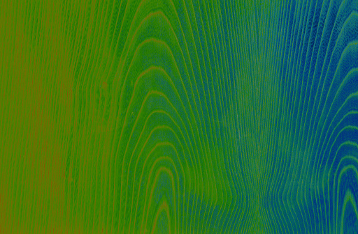 Abstract wood pattern in green, blue and orange tones. Artistic image processing created from wood veneer surface photo. Beautiful wooden texture background for any design