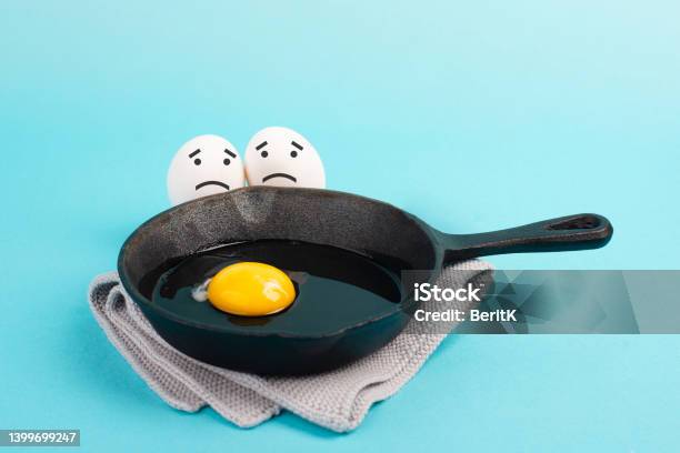 A Fried Egg In A Pan Two Friends Look With Sad Faces At Him Having A Breakfast In The Morning Funny Food Broken Friendship Healthy Food Stock Photo - Download Image Now