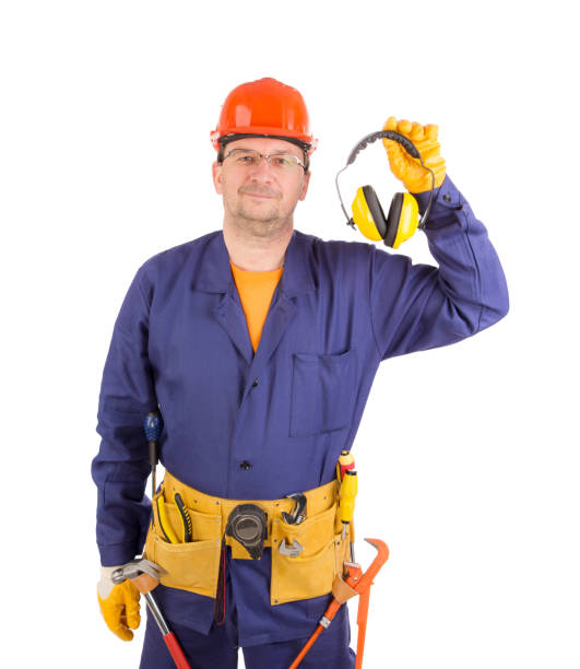 istock Worker in hard hat holds ear muffs in his hands. 1399699321