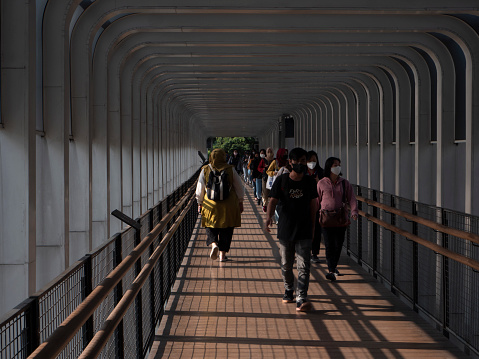 Jakarta, Indonesia-May 27, 2022: Asian people walking on the pedestrian bridge