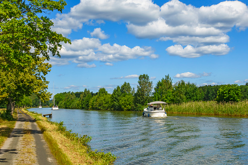Dirt road on a canal with boats in the summer