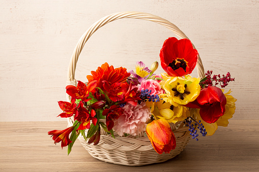 Bright beautiful flowers in a basket on the table. High quality photo