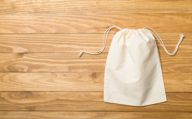 istock Small eco sacks on wooden background. Top view 1399704258