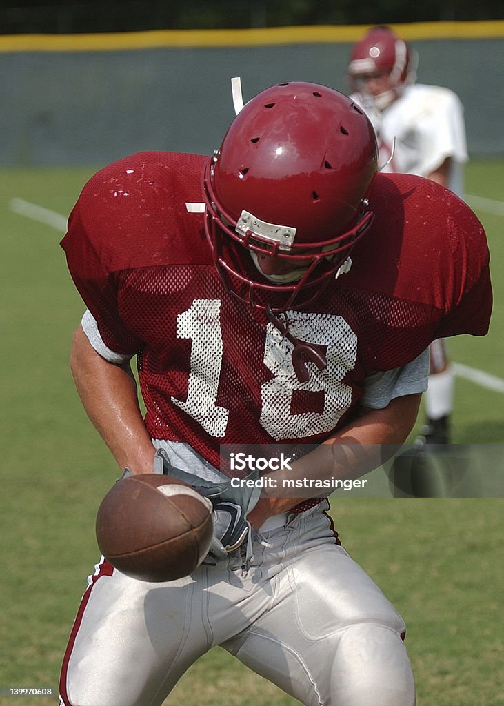 catch high school football player catches football during practice American Football - Ball Stock Photo