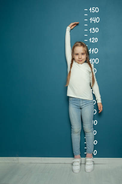 istock Happy beautiful kid girl growth measures on bright blue background 1399706122