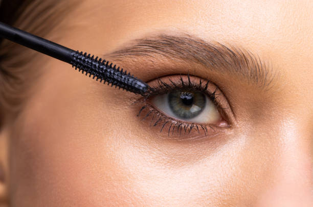 istock Beautiful woman applying mascara on her eyelashes isolated on white 1399708125