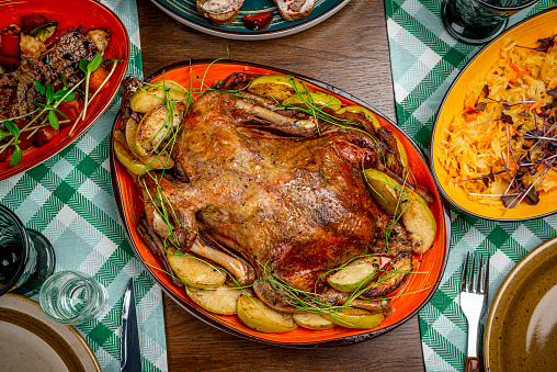 Baked duck with apples on the festive table. Serving a dish in a restaurant, photo for the menu