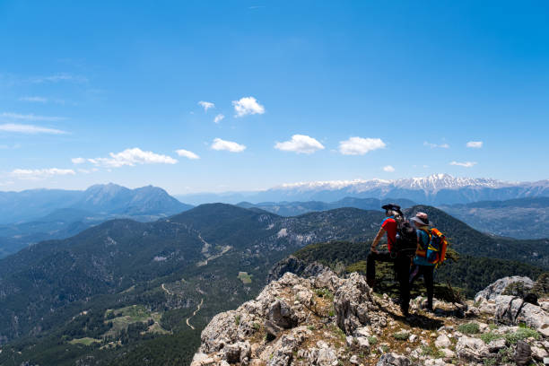 Models full length male 60 years old female 55 years old snowy mountains enjoying wide panoramic view active lifestyles with high vitality