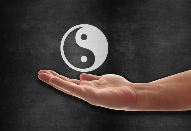 symbol yin yang pod ręką - taoist charm zdjęcia i obrazy z banku zdjęć
