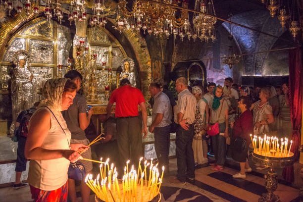 Church of the Holy Sepulcher Jerusalem Jerusalem, Israel - May 03, 2015: Parishioners lighting candles inside the Church of the Holy Sepulcher in the historic center of the city east jerusalem stock pictures, royalty-free photos & images