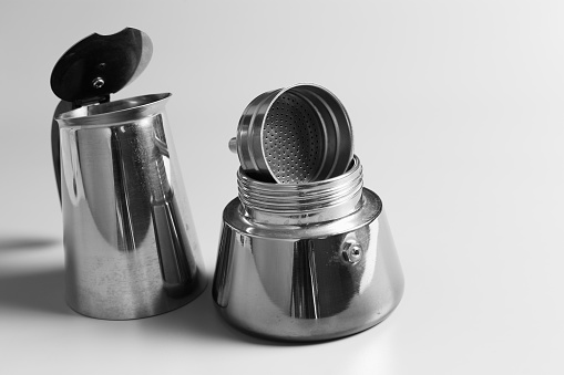 Metal cafetiera or Moka pot coffee maker black and white studio photography.