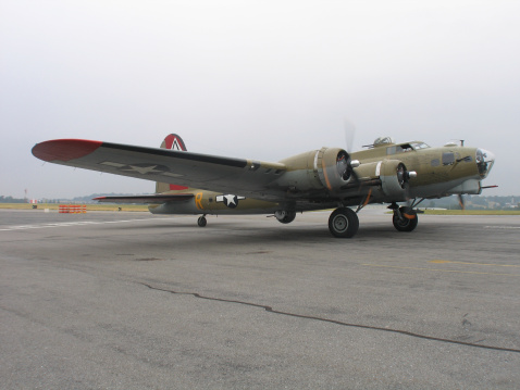 Engine and propeller of military transport plane painted with sky color and parked in an outdoor parking lot