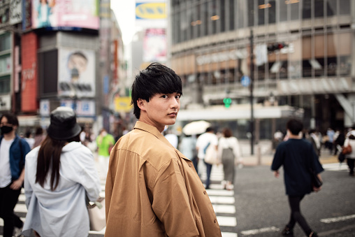 Crowd of people and a young man in downtown district of Shibuya