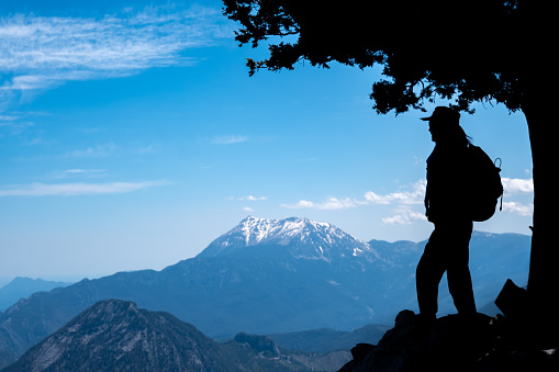 Tahtali mountain mediterranean region nature landscape with open air snowy peak.Silhouette shot model watching view full length with backpack in hat