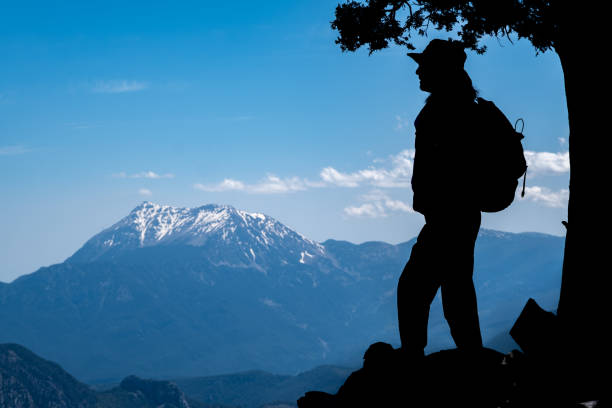 Tahtali mountain mediterranean region nature landscape with open air snowy peak.Silhouette shot model watching view full length with backpack in hat