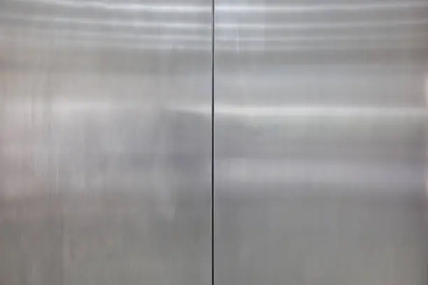 Photo of stainless steel door background and texture. elevator metal door.