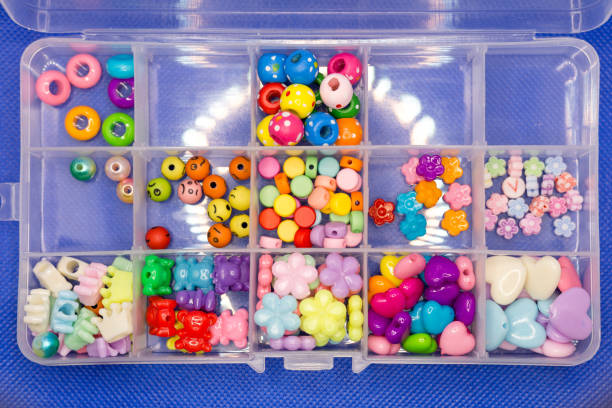 istock Yellow, pink, blue beads of different shapes for needlework in a plastic box 1399724984
