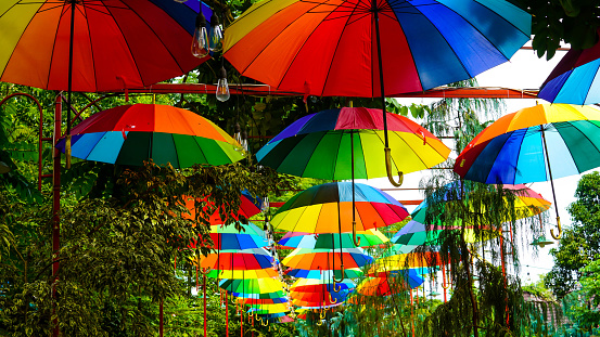 Bogor, West Java 26th June 2021 Rainbow umbrella on sky background. Many colorful umbrellas. umbrella street decoration