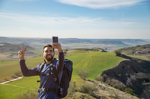 Young bearded man taking a selfie with his smartphone - travel and technology concept