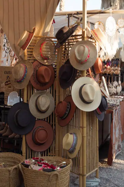 Photo of Handmade palm hats at a famous hippie market called Las Dalias (Sant Carles, Ibiza, Spain). Stall selling handmade accessories at a flea market.