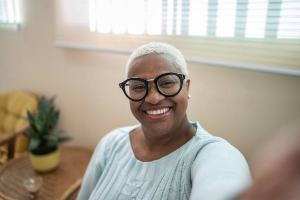mature woman taking a selfie or filming at home - camera point of view - plussize model fotos stockfoto's en -beelden