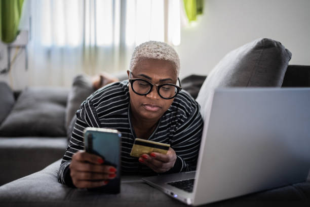 istock Mature women shopping online using mobile phone at home 1399726823