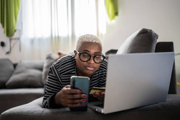 istock Mature women shopping online using mobile phone at home 1399726847
