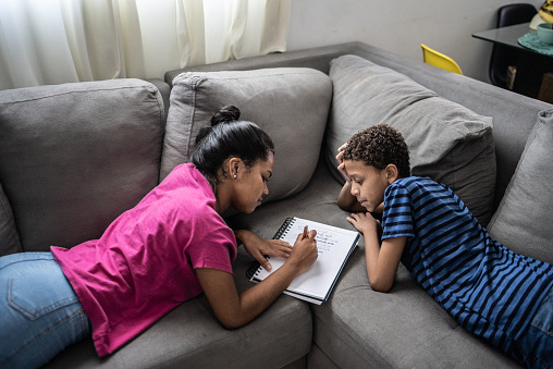 Siblings Writing Sibling Studying And Writing On Note Pad At Home Stock Photo - Download ...