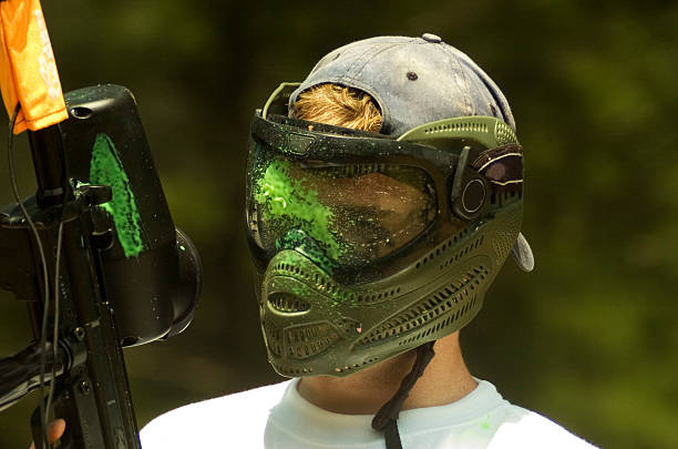 paintball fare schizzi su una maschera facciale - paintballing violence exercising sport foto e immagini stock