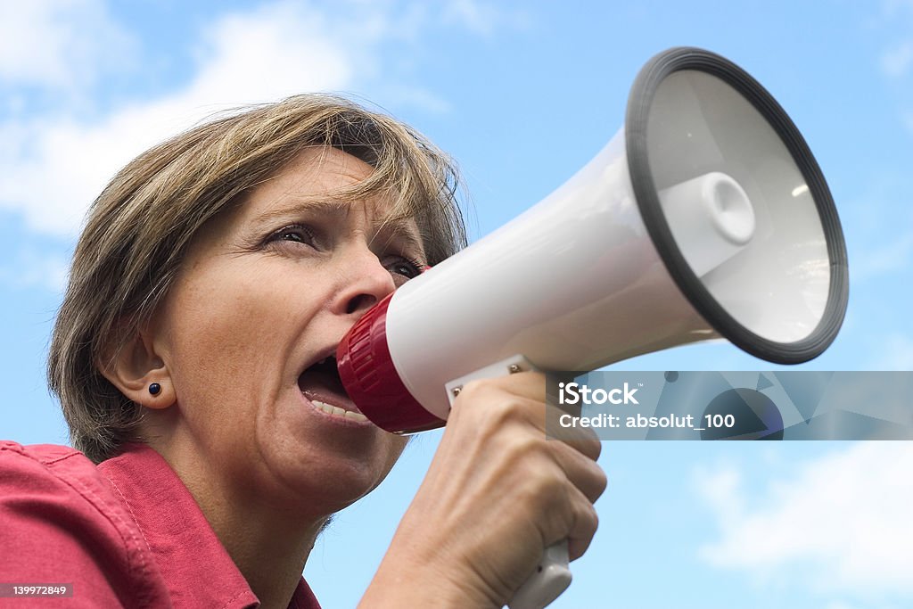 Shouting Middle-aged woman shouting through the megaphone. Mature Adult Stock Photo