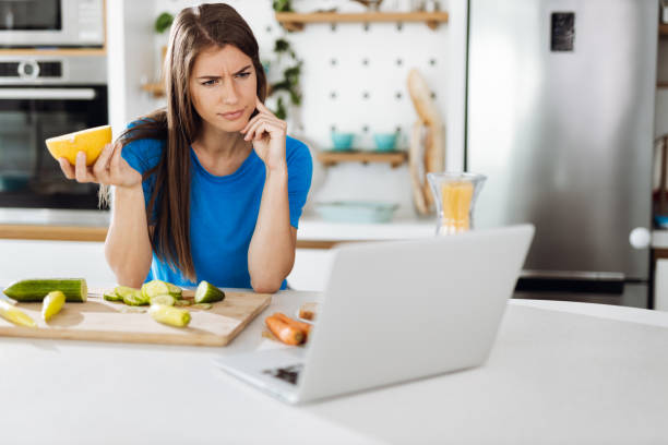 istock Woman reading recipes over Internet in the kitchen 1399728608