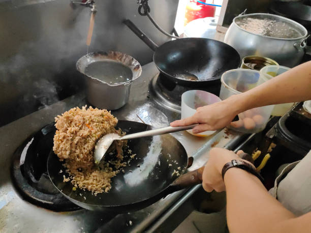 Success An Asian man is running own restaurant - focus in cooking Chinese fried rice successfully. chinese cuisine fried rice asian cuisine wok stock pictures, royalty-free photos & images