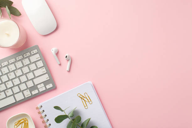 istock Business concept. Top view photo of workspace keyboard computer mouse wireless earbuds clips notebook candle and eucalyptus on isolated pink background with copyspace 1399734642