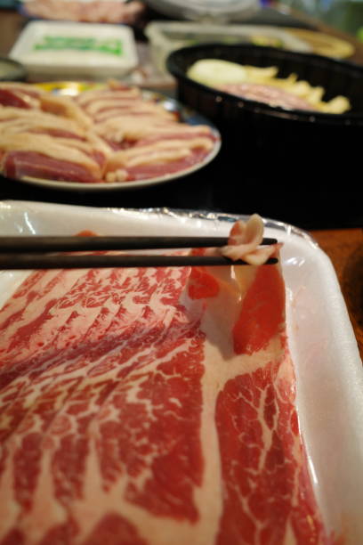 istock Picking up raw sliced beef using chopsticks for shabu shabu 1399736123