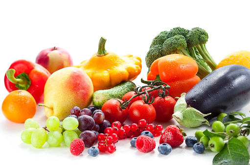 Assorted vegetables and fruits in wooden crate box isolated on white background