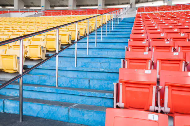 lugares vazios de laranja e amarelos no estádio, passagem de linhas de assento em um estádio de futebol - sports venue - fotografias e filmes do acervo
